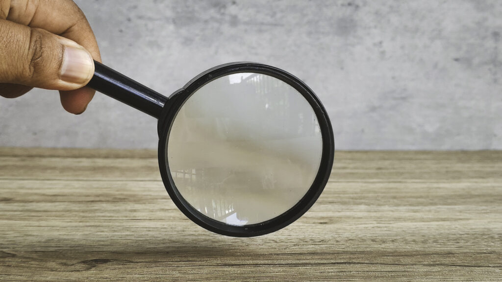 A person looking at how Ethereal Consulting works with a magnifying glass